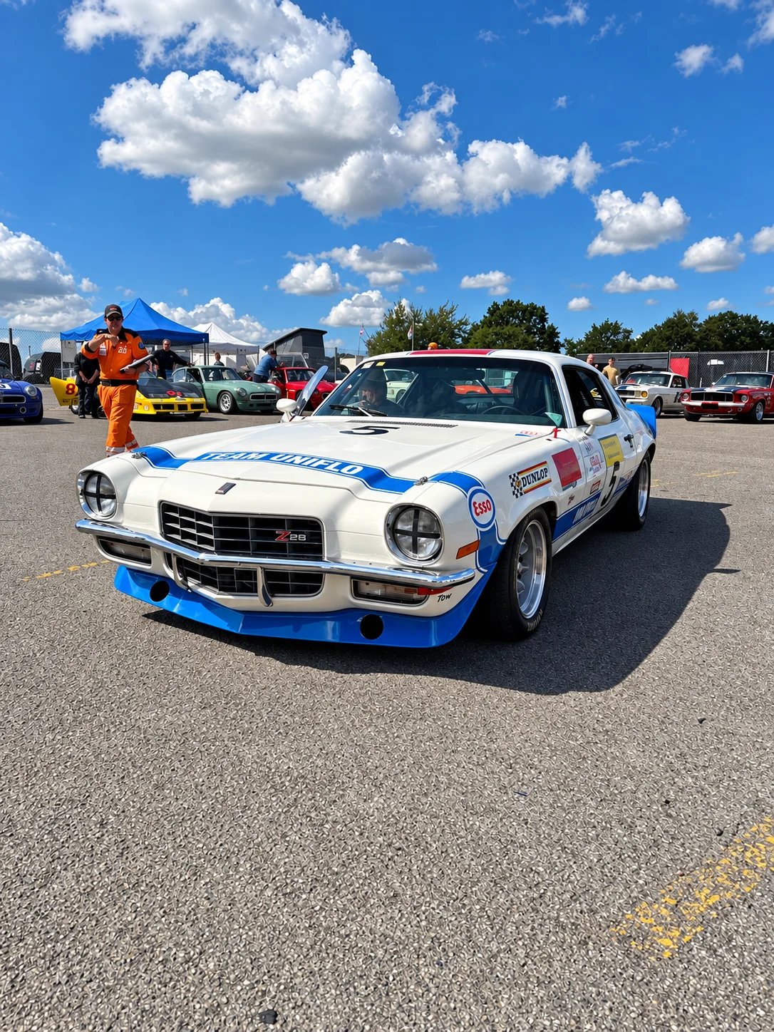 White and blue Camaro Z28 at a sunny race event