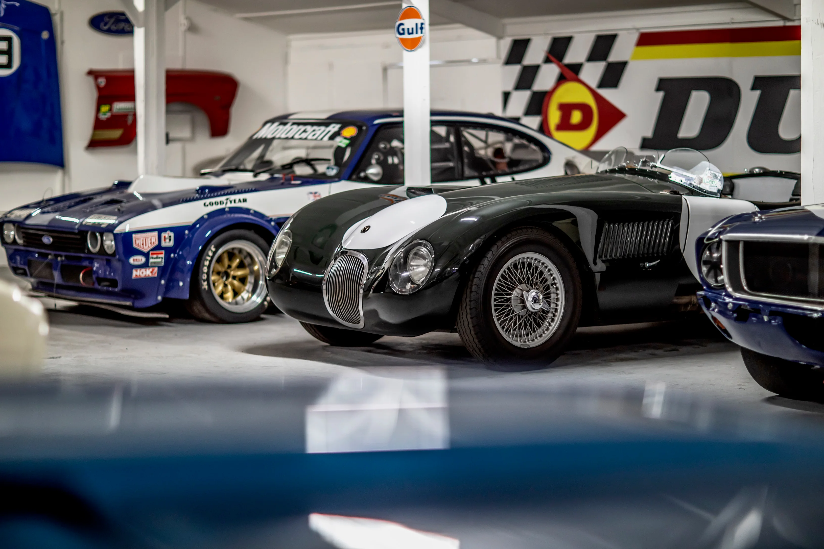 Vintage race cars parked together in the workshop