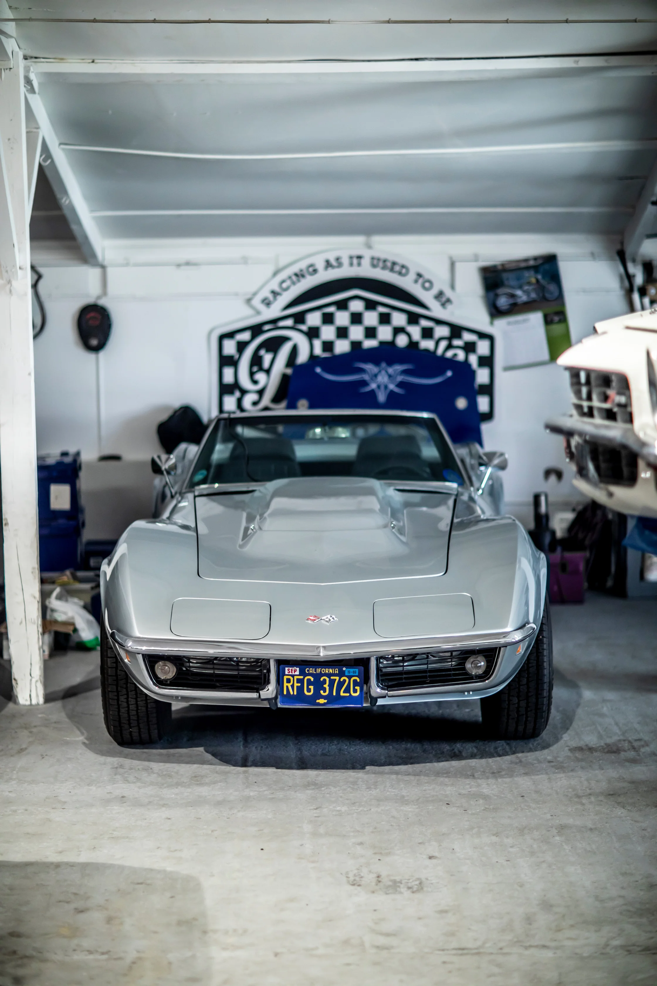 Silver Corvette viewed head-on in the workshop