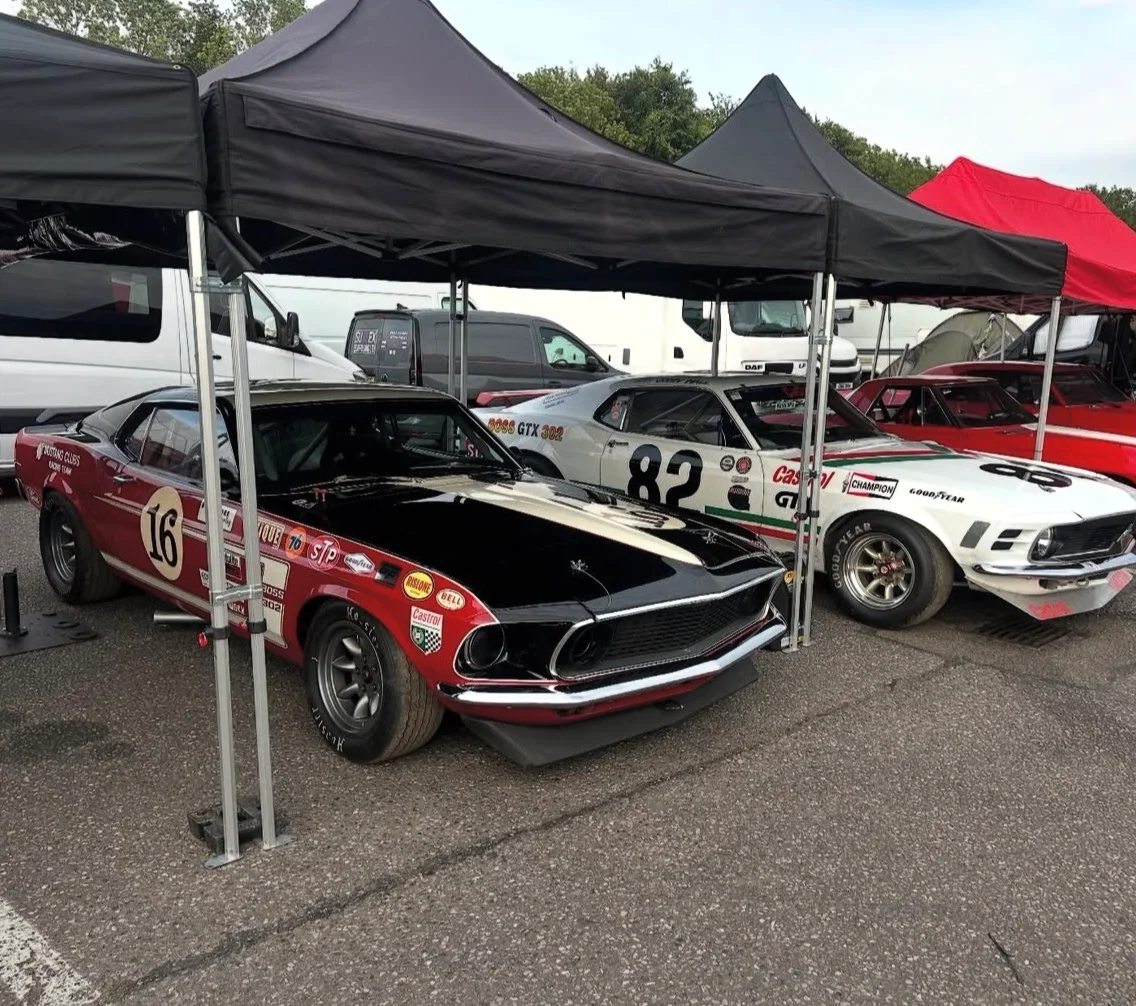 Classic Ford Mustang race cars in the event paddock