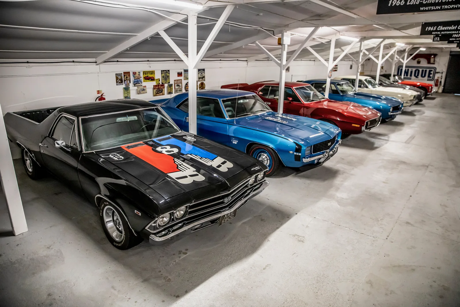 Line of classic cars parked inside The Paddock Club storage facility